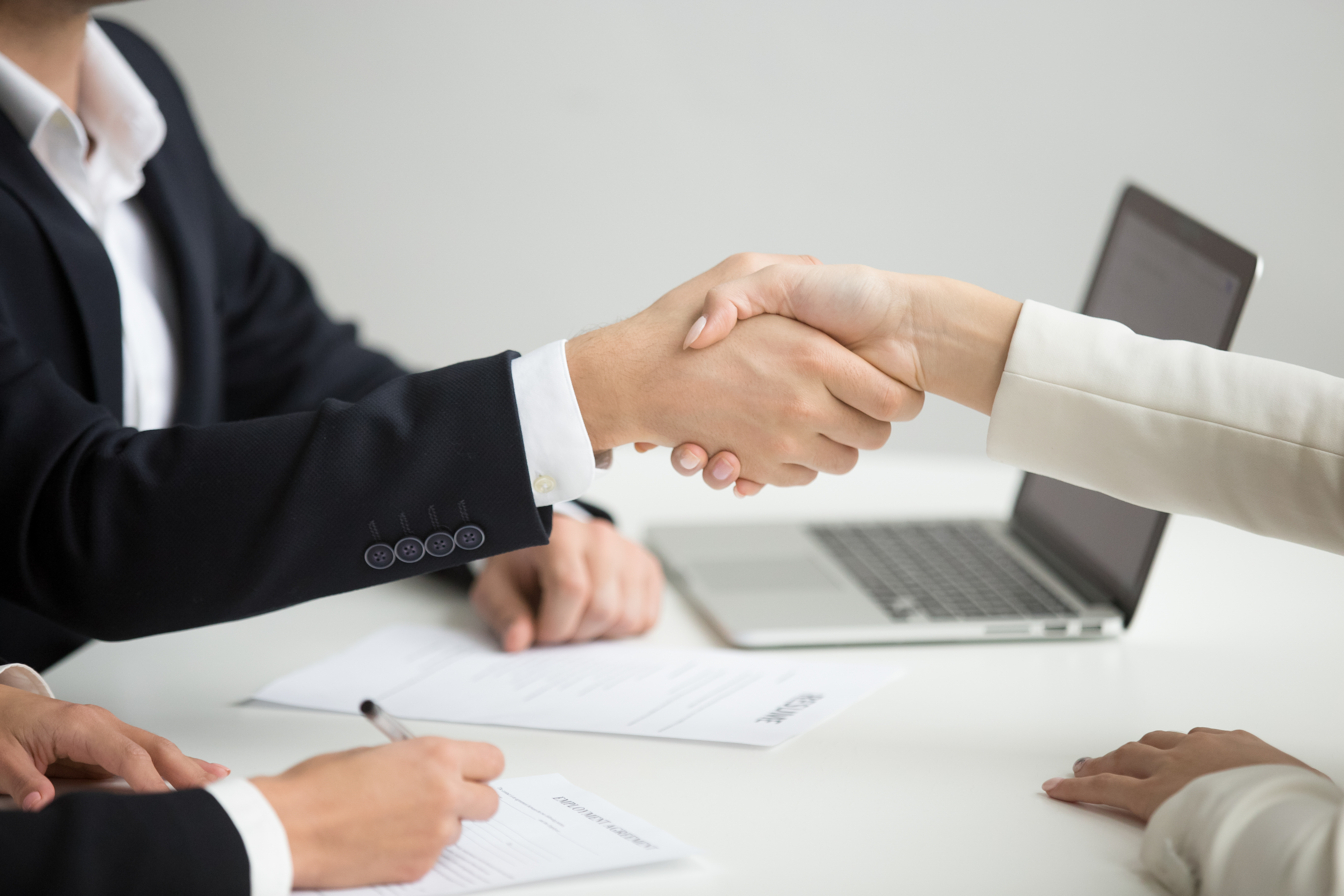 Hr handshaking successful candidate getting hired at new job, cl Employment handshake concept, female hr and successful woman candidate shaking hands getting hired ready to sign job contract concept, employer congratulating welcoming new worker, close up view